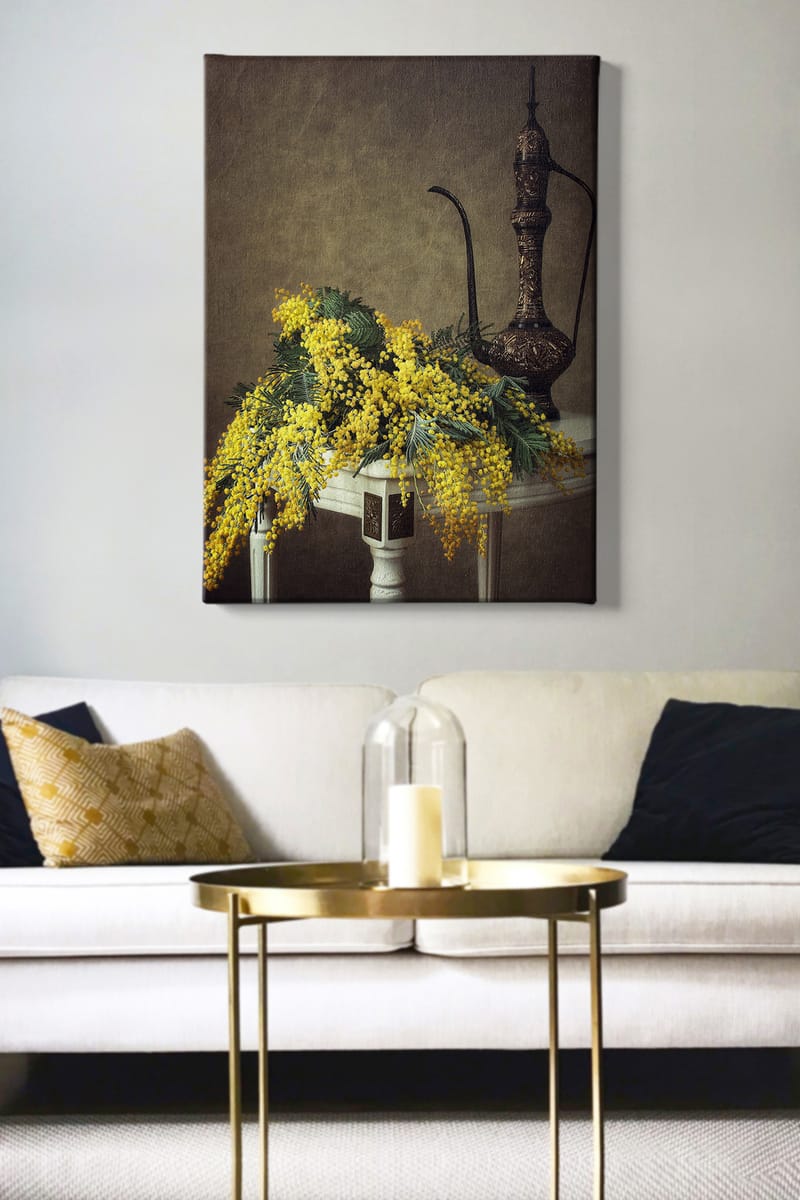 Lærred 70x100 cm - Smuk buket mimosa-blomster i gul, placeret på et bord ved siden af en elegant, mørkebrun kande - Gul / Mørkegrøn / Brun - Boligtilbehør - Billeder & kunst - Billeder på lærred