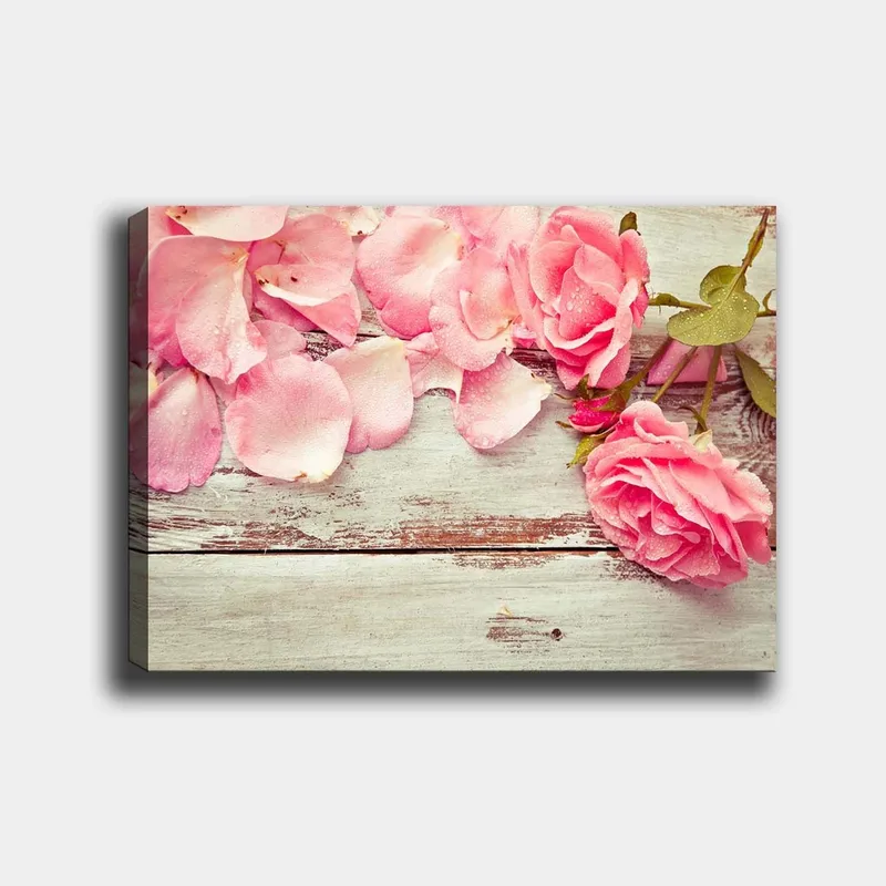 Lærred 70x100 cm - Smuk komposition af lyserøde roser og rosenblade på en træoverflade, Lyserød / Grøn / Brun