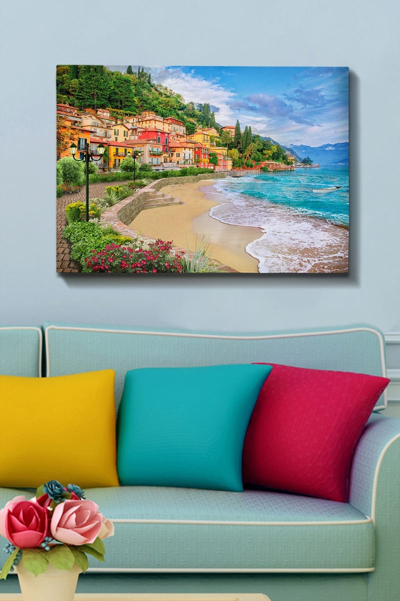 Lærred 70x100 cm - Smuk kystlinje med farverige huse, der klatrer op ad en frodig bakke ved en strand - Blå / Grøn / Gul - Boligtilbehør - Billeder & kunst - Billeder på lærred