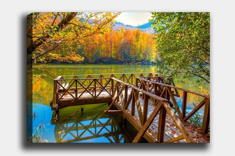 Lærred 70x100 cm - Smuk mole ved en spejlblank sø omgivet af efterårsfarvede træer, Guld / Grøn / Brun