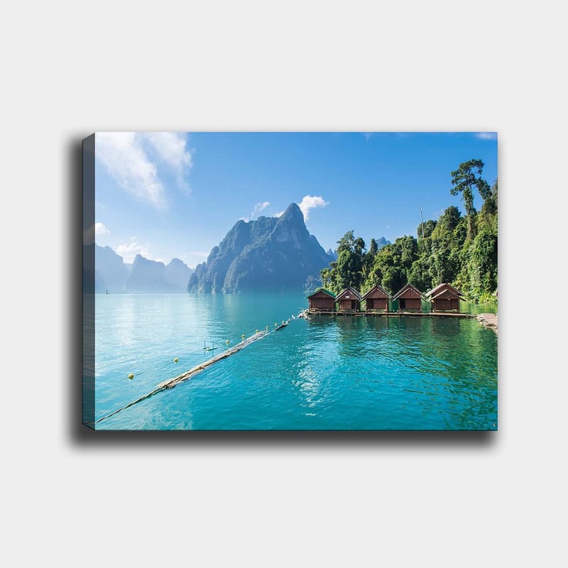 Lærred 70x100 cm - Smuk sø med hytter ved vandet, omgivet af majestætiske bjerge og frodig skov, Turkis / Grøn / Brun