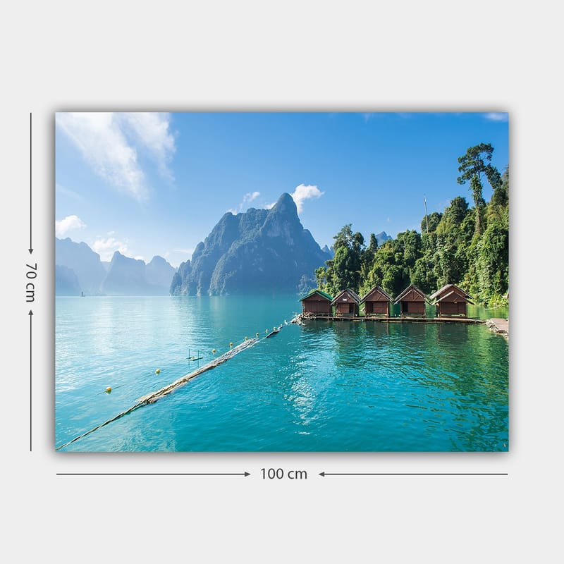 Lærred 70x100 cm - Smuk sø med hytter ved vandet, omgivet af majestætiske bjerge og frodig skov - Turkis / Grøn / Brun - Boligtilbehør - Billeder & kunst - Billeder på lærred