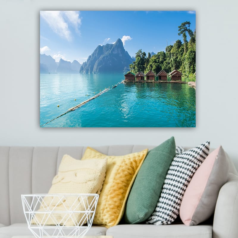 Lærred 70x100 cm - Smuk sø med hytter ved vandet, omgivet af majestætiske bjerge og frodig skov - Turkis / Grøn / Brun - Boligtilbehør - Billeder & kunst - Billeder på lærred