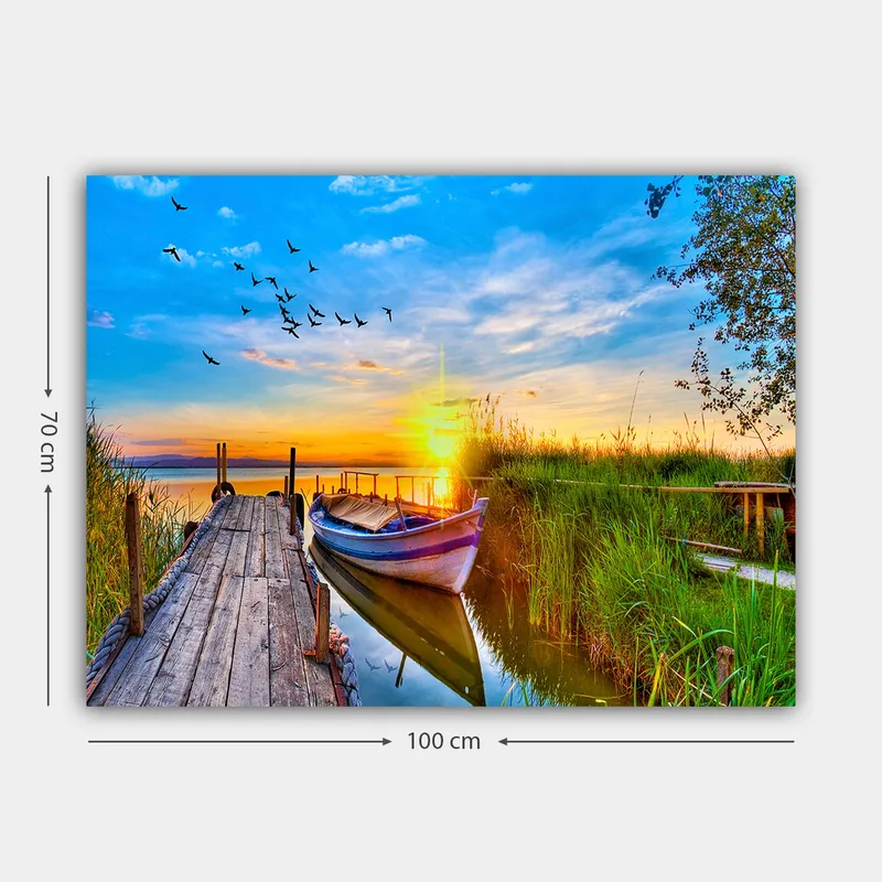 Lærred 70x100 cm - Smuk solnedgang over en rolig sø med en båd ved en træmole omgivet af grønne områder - Blå / Orange / Grøn - Boligtilbehør - Billeder & kunst - Billeder på lærred