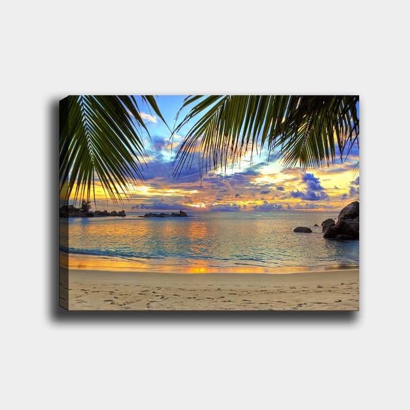 Lærred 70x100 cm - Smuk solnedgang over en strand med palmer, der indrammer motivet, Blå / Orange / Grøn