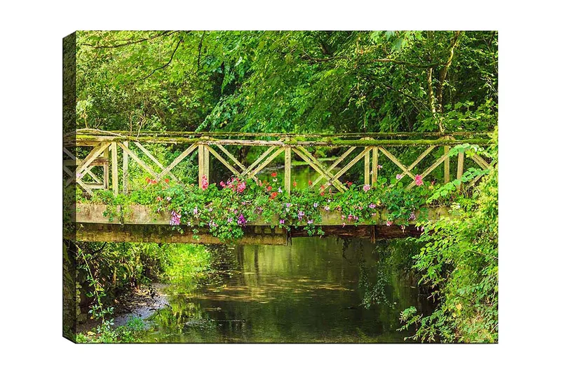 Lærred 70x100 cm - Smuk træbro omgivet af grønne områder og blomster ved en rolig vandoverflade, Grøn / Lyserød / Brun