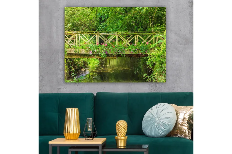 Lærred 70x100 cm - Smuk træbro omgivet af grønne områder og blomster ved en rolig vandoverflade - Grøn / Lyserød / Brun - Boligtilbehør - Billeder & kunst - Billeder på lærred