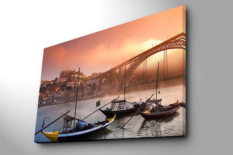 Lærred 70x100 cm - Smuk udsigt over floden med traditionelle både og en majestætisk bro i baggrunden, omgivet af farverige huse - Orange / Blå / Gul - Boligtilbehør - Billeder & kunst - Billeder på lærred