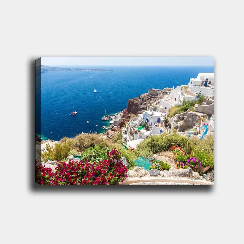 Lærred 70x100 cm - Smuk udsigt over Santorini med hvide huse og blomster, der pryder klipperne ved havet, Blå / Hvid / Grøn