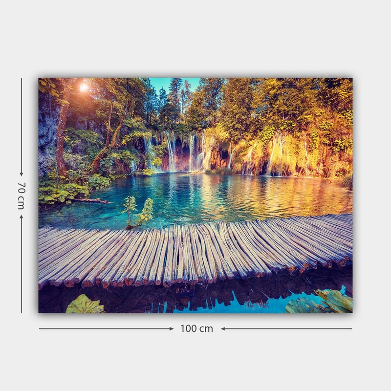 Lærred 70x100 cm - Smukt vandfald med klart blåt vand omgivet af frodigt grønt og træer - Blå / Grøn / Brun - Boligtilbehør - Billeder & kunst - Billeder på lærred