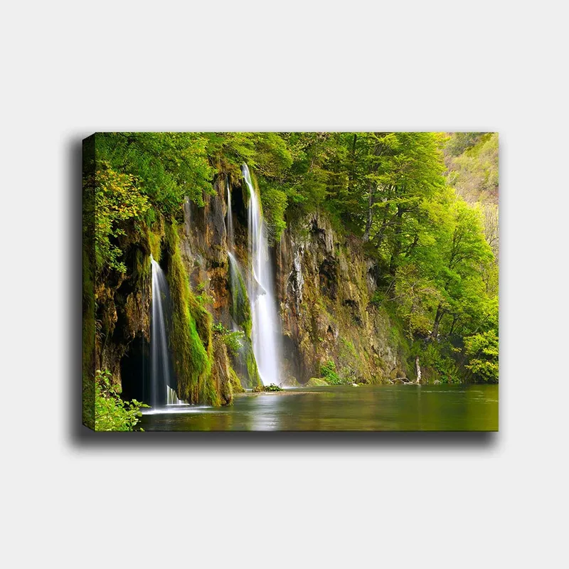 Lærred 70x100 cm - Smukt vandfald omgivet af frodigt grønt, Grøn / Brun / Hvid