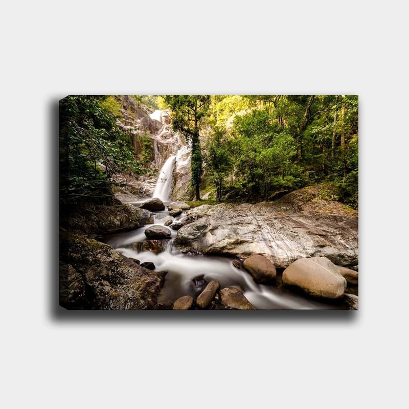 Lærred 70x100 cm - Smukt vandfald omgivet af frodigt grønt og klippeblokke, Grøn / Grå / Brun