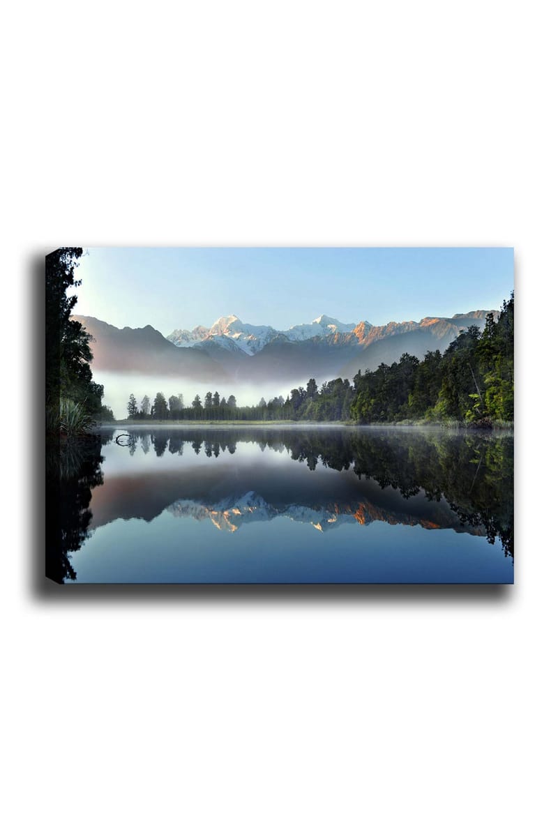 Lærred 70x100 cm - Spejlbillede af majestætiske bjerge spejlet i en rolig sø omgivet af frodig skov, Blå / Grøn / Hvid