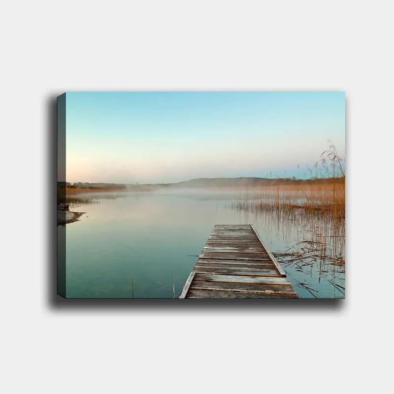 Lærred 70x100 cm - Stille mole strækker sig over en tåget sø ved daggry, Lyseblå / Beige / Grøn