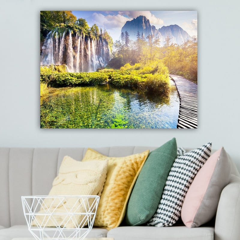 Lærred 70x100 cm - Storslået vandfald omgivet af frodig vegetation og majestætiske bjerge - Grøn / Blå / Gul - Boligtilbehør - Billeder & kunst - Billeder på lærred