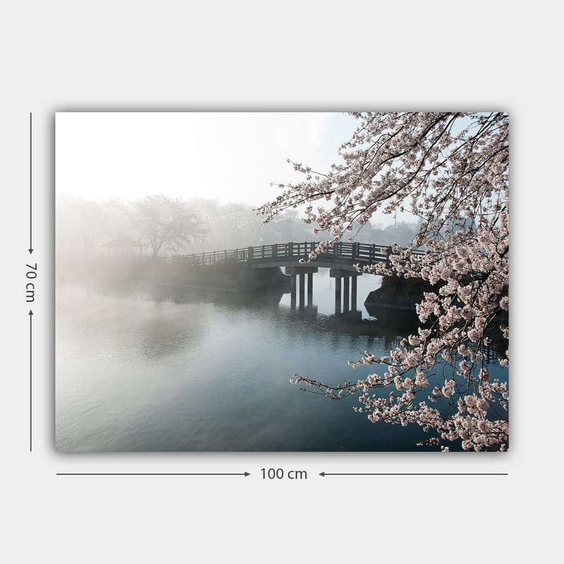Lærred 70x100 cm - Tåget landskab med en bro, der spænder over en stille sø, omgivet af blomstrende kirsebærtræer - Lys pink / Blå / Grå - Boligtilbehør - Billeder & kunst - Billeder på lærred