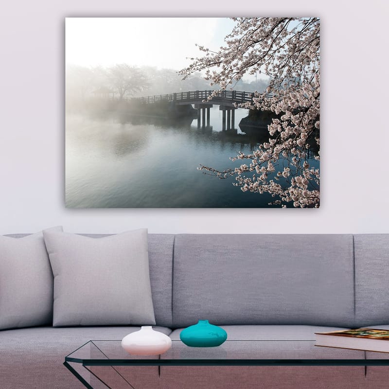 Lærred 70x100 cm - Tåget landskab med en bro, der spænder over en stille sø, omgivet af blomstrende kirsebærtræer - Lys pink / Blå / Grå - Boligtilbehør - Billeder & kunst - Billeder på lærred