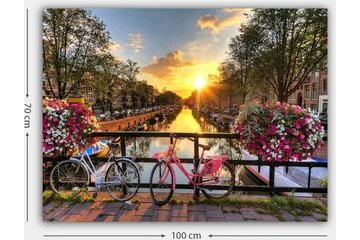 Lærred 70x100 cm - To cykler i malerisk kanal med blomster og solnedgang - Lyserød / Hvid / Grøn - Boligtilbehør - Billeder & kunst - Billeder på lærred