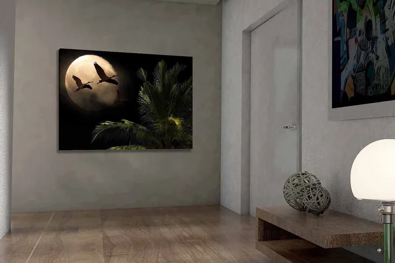 Lærred 70x100 cm - To fugle der flyver mod en stor måne over en palmelignende plante, Mørkegrøn / Grå / Beige