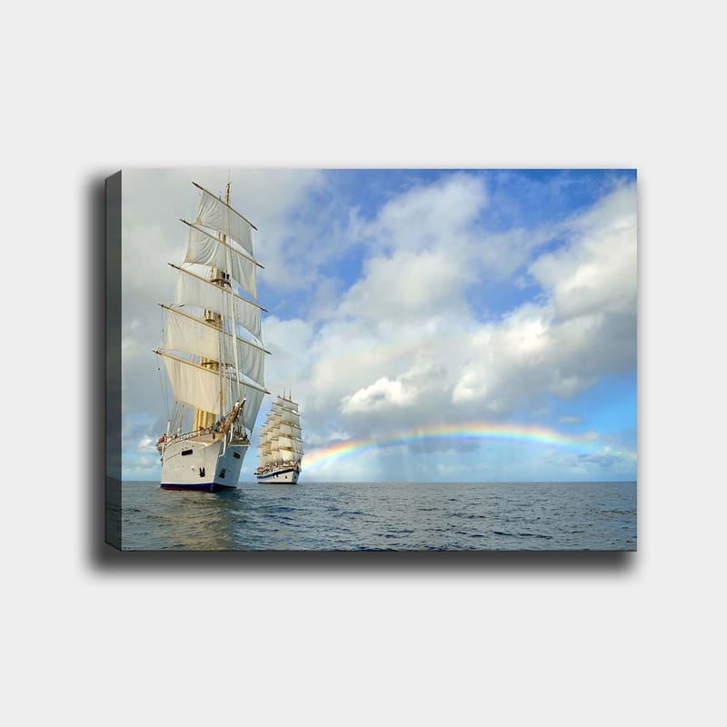 Lærred 70x100 cm - To sejlbåde, der sejler gennem et roligt hav under en blå himmel med skyer og en regnbue, Hvid / Blå / Grå