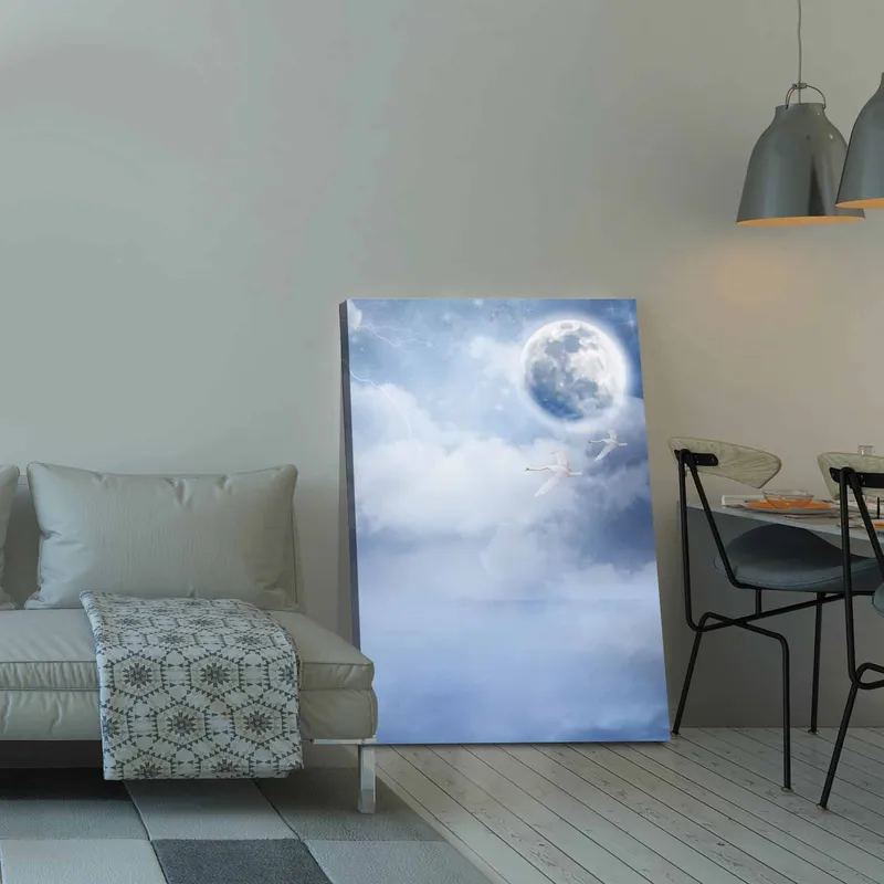 Lærred 70x100 cm - To svaner der flyver under en stor måne på en drømmende, overskyet himmel - Lyseblå / Hvid / Mørkeblå - Boligtilbehør - Billeder & kunst - Billeder på lærred