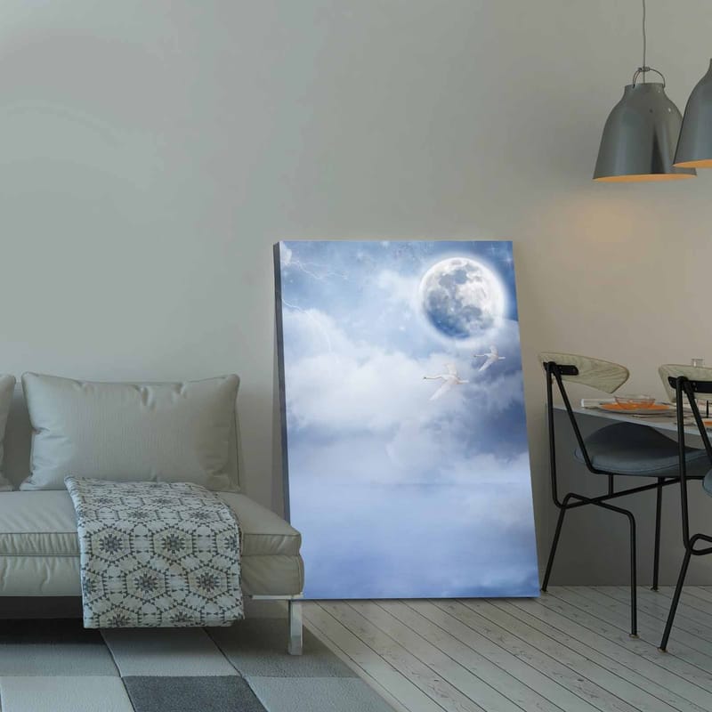 Lærred 70x100 cm - To svaner der flyver under en stor måne på en drømmende, overskyet himmel - Lyseblå / Hvid / Mørkeblå - Boligtilbehør - Billeder & kunst - Billeder på lærred