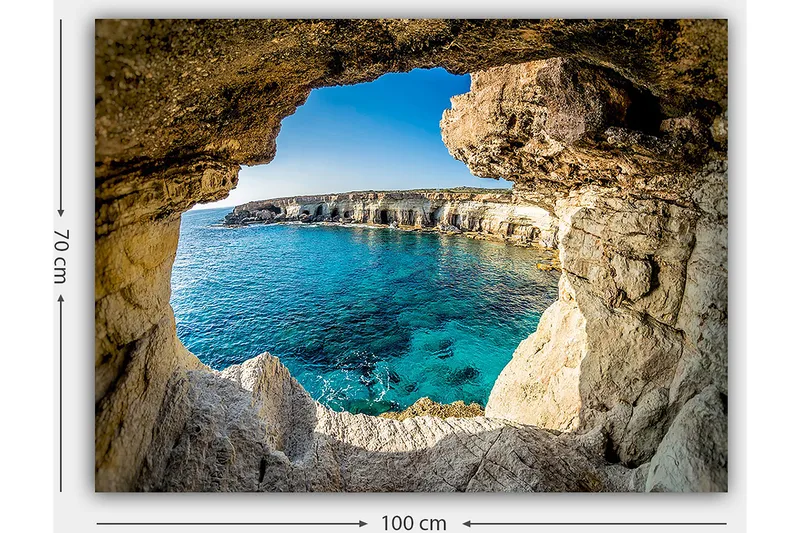 Lærred 70x100 cm - Udsigt gennem en klippeåbning mod en klar blå kyst - Blå / Beige / Hvid - Boligtilbehør - Billeder & kunst - Billeder på lærred