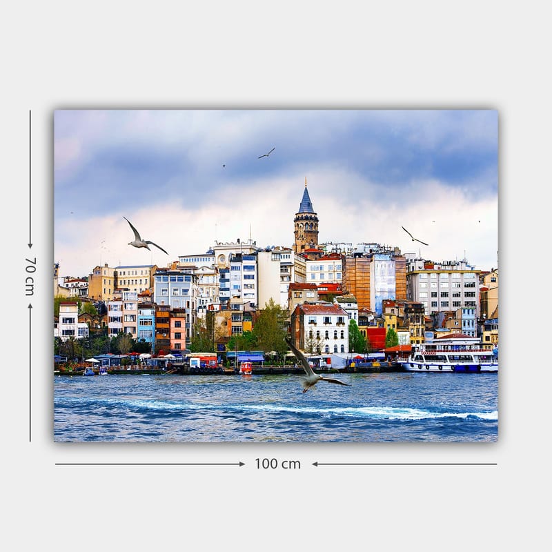 Lærred 70x100 cm - Udsigt over en by med et historisk klokketårn og fugle, der svæver over vandet - Blå / Hvid / Beige - Boligtilbehør - Billeder & kunst - Billeder på lærred