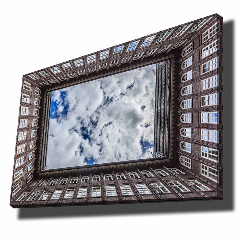 Lærred 70x100 cm - Udsigt over en bygningsfacade, der indrammer et spejlbillede af himlen, Mørkebrun / Hvid / Lyseblå