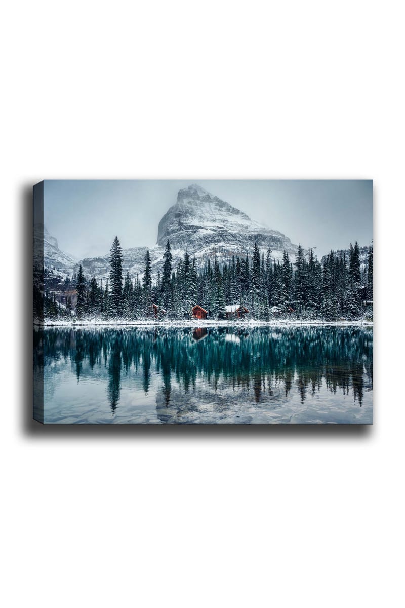 Lærred 70x100 cm - Vinterlandskab med snedækkede bjerge og en spejlblank sø omgivet af grantræer og røde hytter, Mørkegrøn / Blå / Hvid