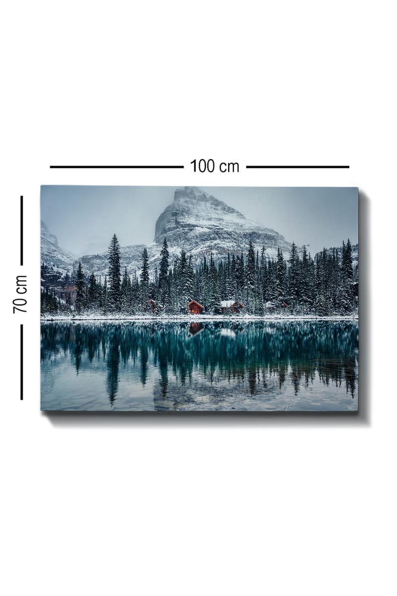 Lærred 70x100 cm - Vinterlandskab med snedækkede bjerge og en spejlblank sø omgivet af grantræer og røde hytter - Mørkegrøn / Blå / Hvid - Boligtilbehør - Billeder & kunst - Billeder på lærred
