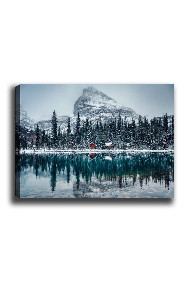 Lærred 70x100 cm - Vinterlandskab med snedækkede bjerge og en spejlblank sø omgivet af grantræer og røde hytter, Mørkegrøn / Blå / Hvid