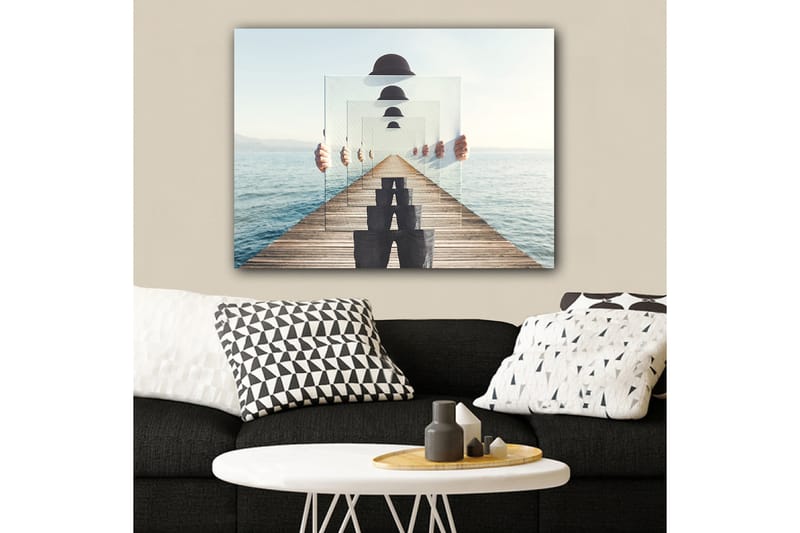 Lærred 70x100 cm - Person, der holder flere gennemsigtige paneler op, skaber en illusion af dybde og perspektiv på en mole ved vandet - Blå / Sort / Hvid - Boligtilbehør - Billeder & kunst - Billeder på lærred