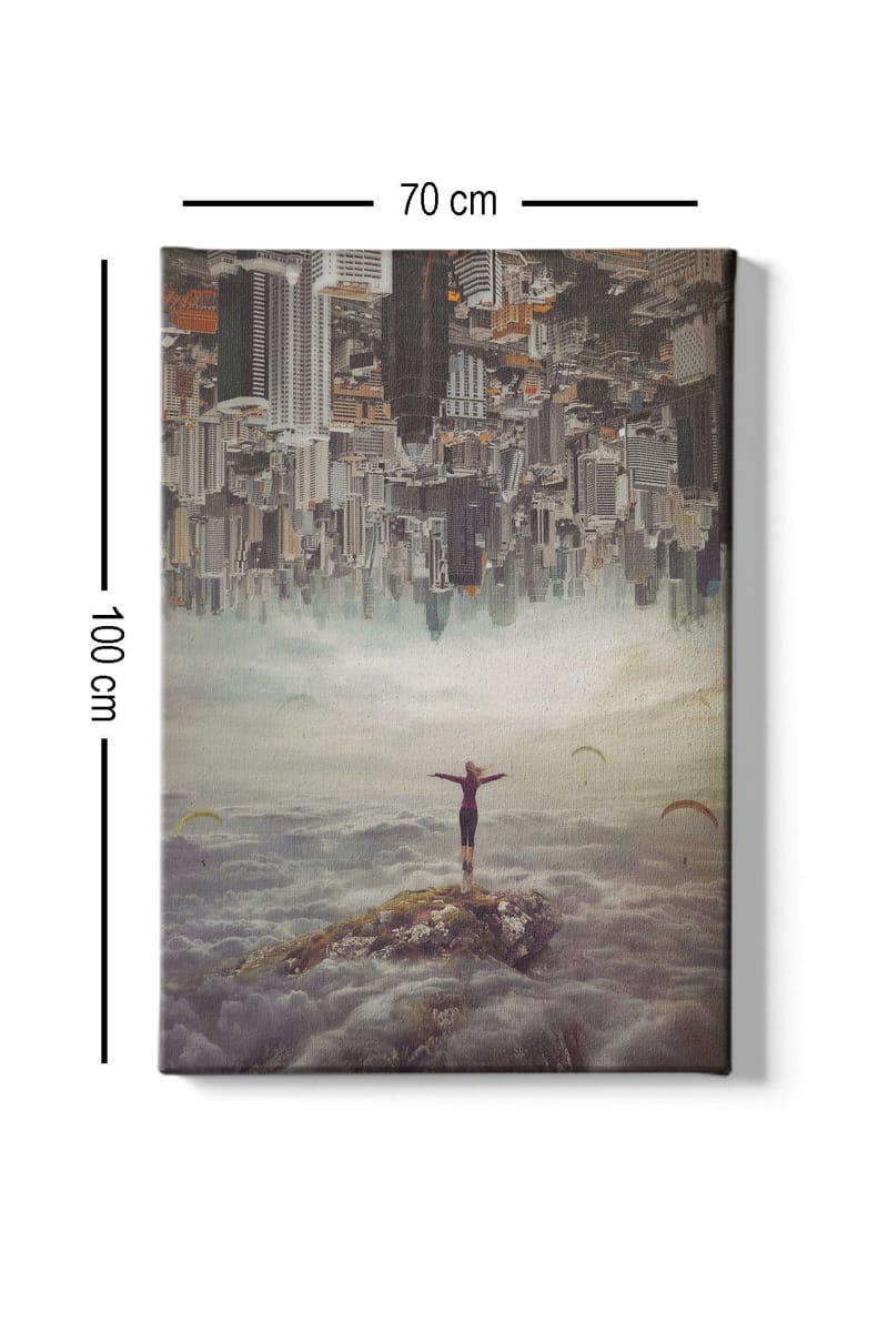 Lærred 70x100 cm - Person stående med udstrakte arme på en klippe over skyerne, med en by i baggrunden, der er vendt på hovedet - Grå / Beige / Mørkeblå - Boligtilbehør - Billeder & kunst - Billeder på lærred