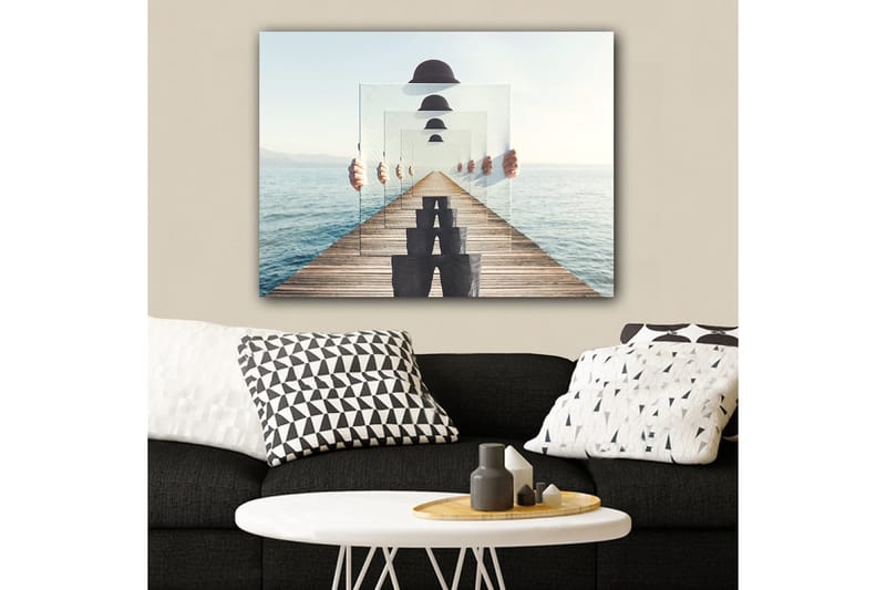 Lærred 70x100 cm - Person, der holder flere gennemsigtige paneler op, skaber en illusion af dybde og perspektiv på en mole ved vandet - Blå / Sort / Hvid - Boligtilbehør - Billeder & kunst - Billeder på lærred