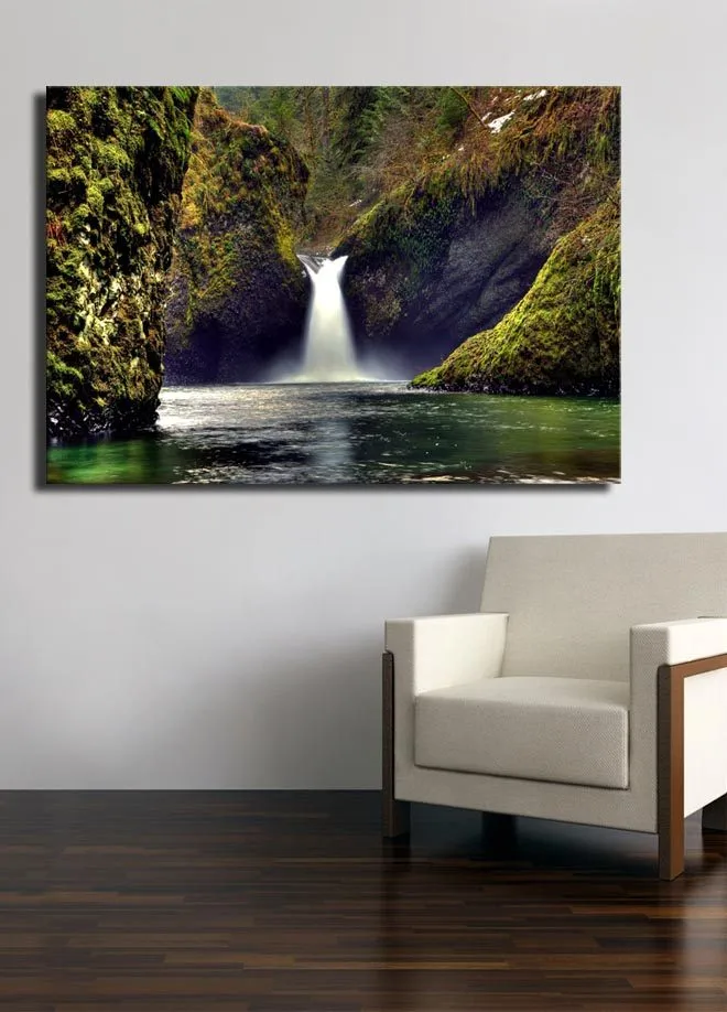 Lærredsbillede 70x100 cm - Smukt vandfald der flyder ned mellem grønne klipper i et naturskønt miljø - Grøn / Blå / Brun - Boligtilbehør - Billeder & kunst - Billeder på lærred