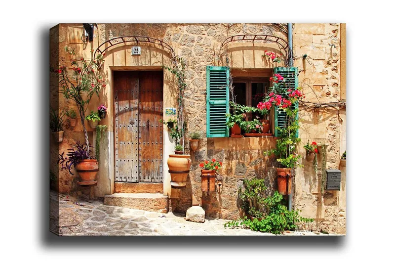 Lærredsbillede - Charmerende husfacade med blomster og grønne skodder, Terrakotta / Grøn / Beige