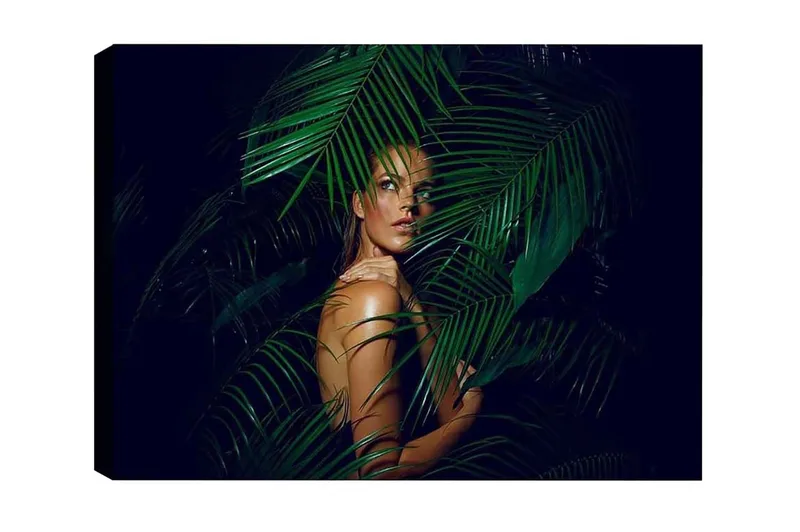 Lærredsbillede - Kvinde delvist skjult bag grønne palmeblade, Mørkegrøn / Hudtone / Sort