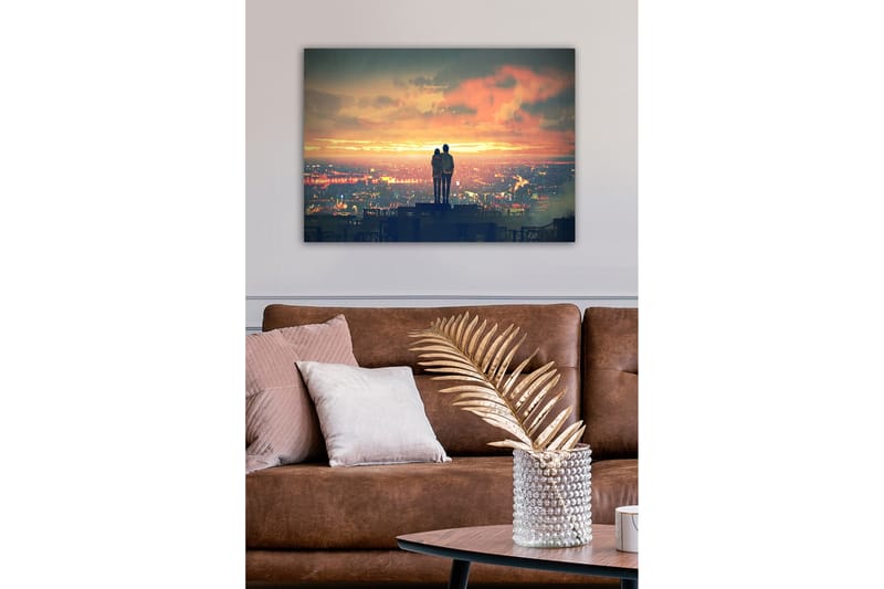 Lærredsbillede - Par står sammen og ser en solnedgang over en by - Orange / Blå / Grå - Boligtilbehør - Billeder & kunst - Billeder på lærred