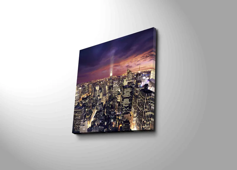 Lærredstryk 45x45 cm - Storslået udsigt over en by i skumringen med funklende lys, Mørkeblå / Lilla / Guld