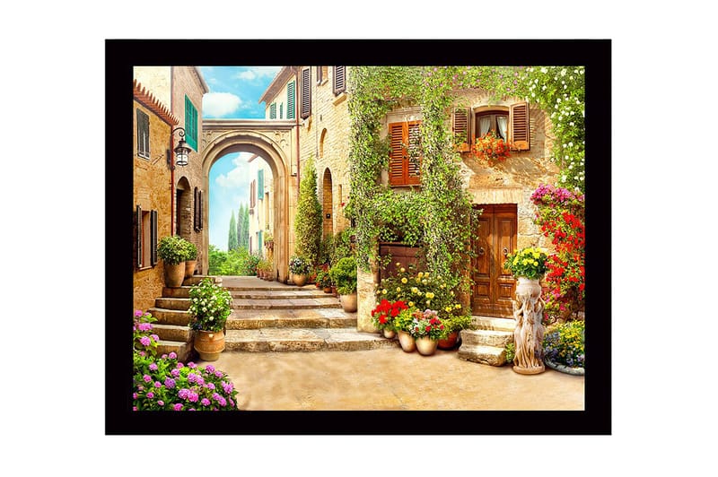 Indrammet lærredstryk i træ - 41x56 cm - Charmerende gyde med blomsterudsmykkede huse og en bue i baggrunden, Grøn / Gul / Lyserød