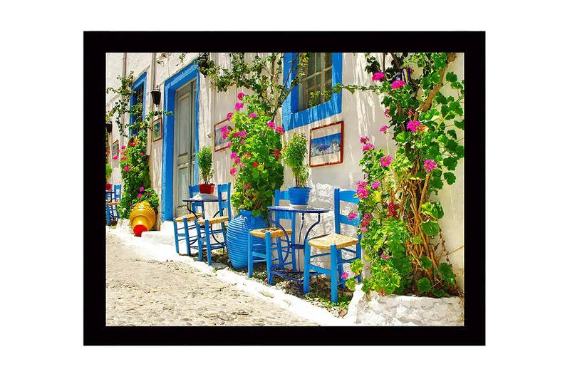 Indrammet lærredstryk i træ - 41x56 cm - Farverigt udendørs spiseområde med blå stole og blomstrende planter, Blå / Grøn / Lyserød