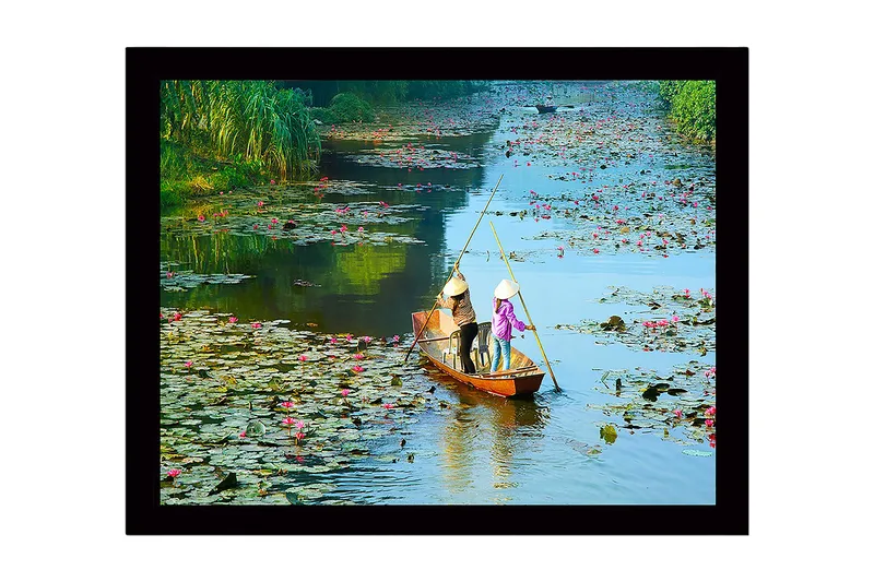 Indrammet lærredstryk i træ - 41x56 cm - Fisker i en båd omgivet af åkander, Grøn / Lyserød / Blå