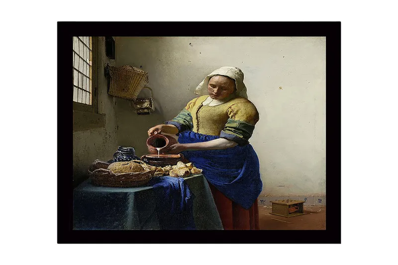 Indrammet lærredstryk i træ - 41x56 cm - Kvinde hælder mælk i en skål ved et bord med brød og keramik, Blå / Gul / Brun