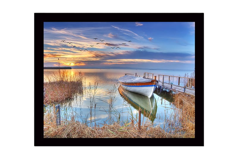 Indrammet lærredstryk i træ - 41x56 cm - Smuk solnedgang over en rolig sø med en båd ved molen, Blå / Orange / Grøn