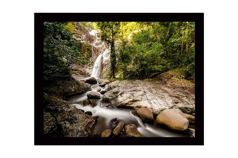 Indrammet lærredstryk i træ - 41x56 cm - Vandfald der flyder gennem et frodigt skovmiljø, Grøn / Grå / Brun