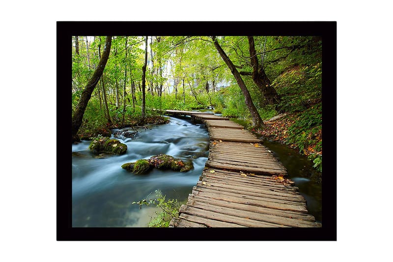 Indrammet trælærredstryk - 41x56 cm - Frodig skovsti med en træbro, der krydser en rislende bæk, Grøn / Brun / Blå