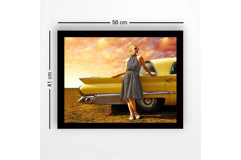 Indrammet trælærredstryk - 41x56 cm - Kvinde i prikket kjole læner sig op ad en veteranbil - Gul / Sort / Hvid - Boligtilbehør - Billeder & kunst